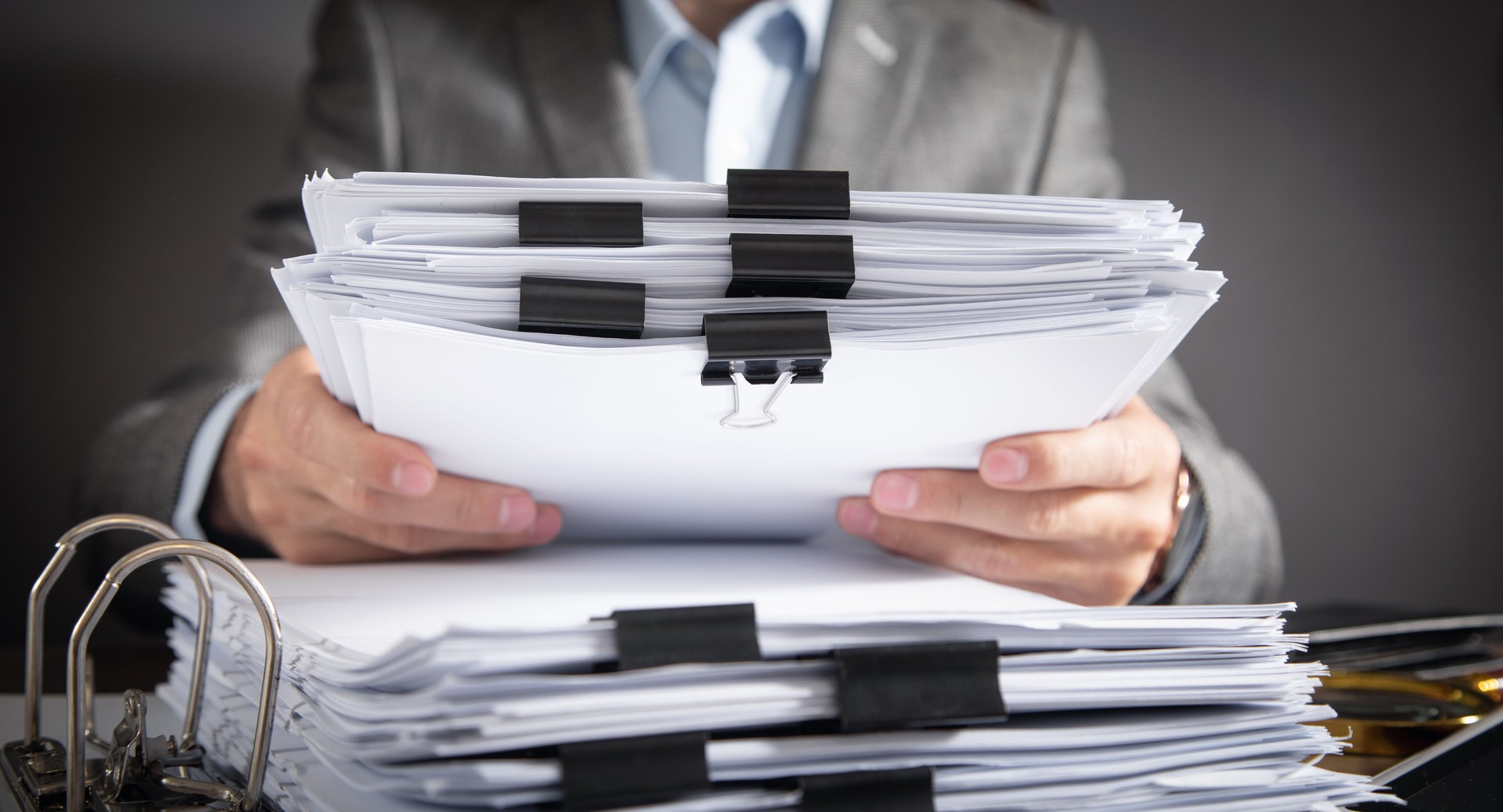 Caucasian businessman holding documents in office.